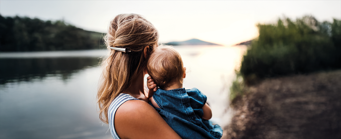 Frau mit Kind am Arm in der Natur, Imagebild Elternteilzeit &copy; Halfpoint - stock.adobe.com