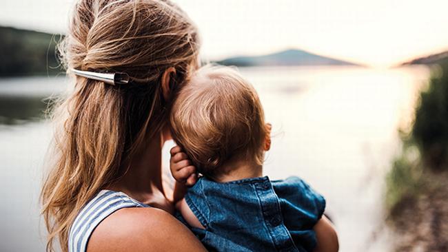 Frau mit Kind am Arm in der Natur, Imagebild Elternteilzeit &copy; Halfpoint - stock.adobe.com