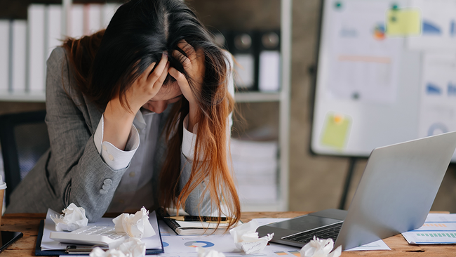 Kranke Frau sitzt an Büro-Schreibtisch © Adobe Stock, mrmohock