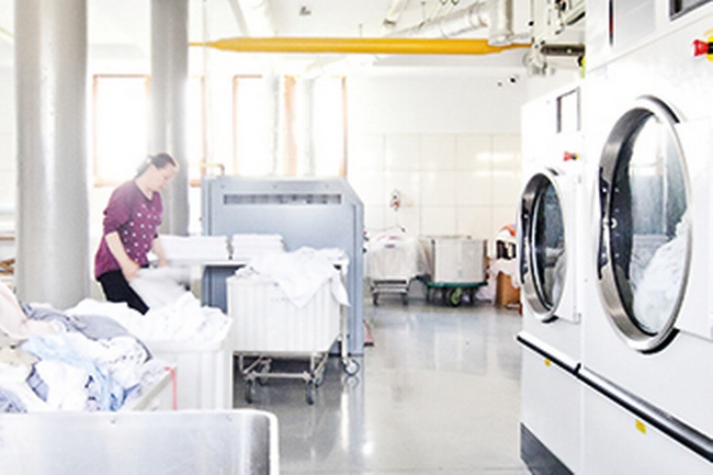 Beschäftigte in einem Waschsalon zum Thema Mindestlohn in Europa © AdobeStock_Maciek