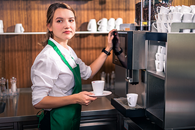 Kellnerin an der Kaffeemaschine. Foto zum Thema Minusstunden © Markus Zahradnik